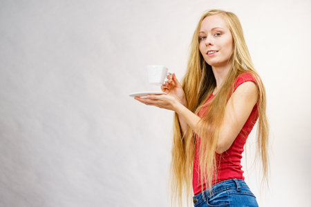 Blonde long hair woman with heart shaped coffee cup. Time to wake up, switching on. copy space.の写真素材
