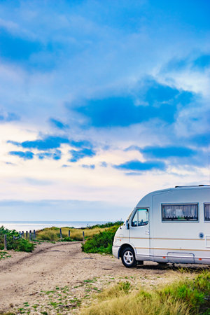 Camper rv caravan on mediterranean coast in Spain. Wild camping on nature beach. Holidays and traveling in motor home.の写真素材