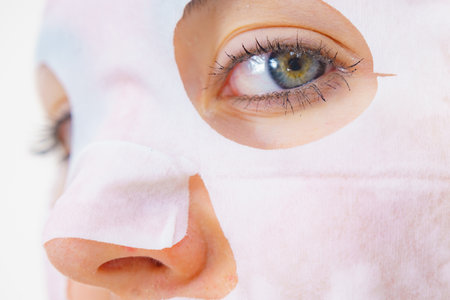Woman with sheet mask on her face. Girl taking care of skin. Beauty treatment. Skincare.の写真素材