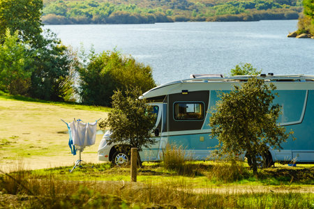 Camping on nature, road trip. Laundry clothes hanging to dry outdoor by camper car.の写真素材
