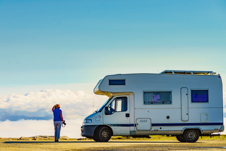 Woman enjoying mountain view, taking travel photo, traveling with caravan. Serra da Estrela in Portugal. Adventure and holidays with mobile home.の写真素材