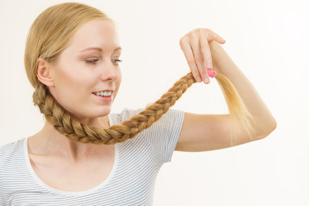 Blonde girl with long braid hair around the neck. Haircare, hairstyling.の写真素材