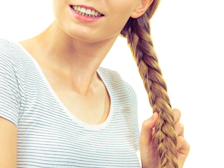 Blonde girl with long braid hair. Haircare, popular hairstyle.の写真素材