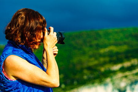 Tourist mature woman take travel picture from mountain hill landscape in France.の写真素材