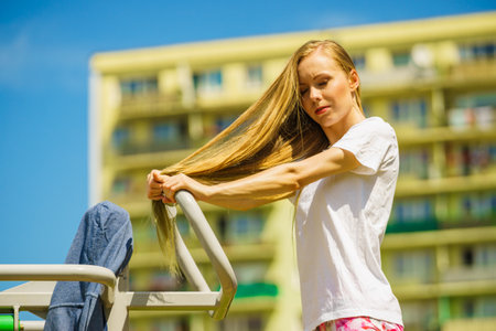 Young woman working out outside. Girl making exercises and training on public equipment in outdoor gym at park. Healthy lifestyle.の写真素材