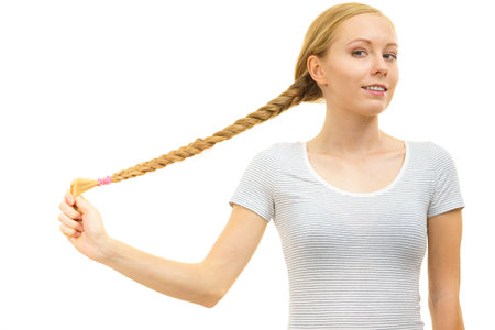 Blonde girl with long braid hair. Haircare, hairstyling, feminine style.の写真素材