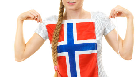 Blonde female student holding Norwegian flag on her chest. Travel and education. Learning foreign languages.の写真素材