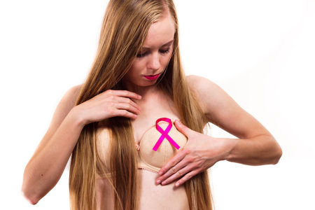Woman with pink ribbon on chest. Treatment and prevention of breast cancer.の写真素材