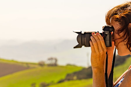 Tourist mature woman take travel picture from mountain hill landscape in Spain.の写真素材
