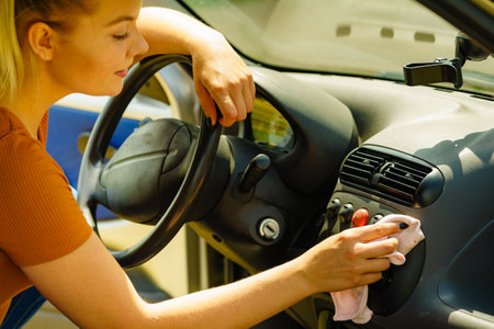 Woman cleaning car dashboard with cloth.の写真素材