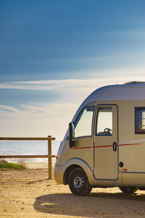 Camper rv caravan on mediterranean coast in Spain. Wild camping on nature beach. Holidays and traveling in motor home.の写真素材