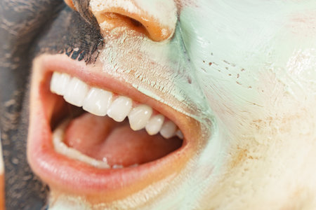 Woman cleaning skin face, using green mud and carbon black mask. Girl taking care of oily...