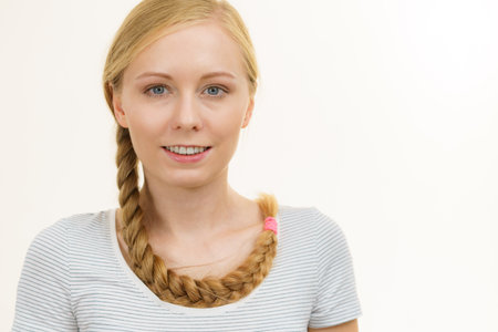 Blonde girl with long braid hair around the neck. Haircare, hairstyling.の写真素材