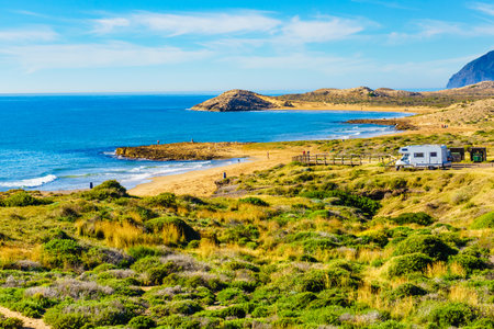 Sea coastal landscape with camper rv camping on beach in the distance. Spain Murcia region, Calblanque Nature Park.の写真素材