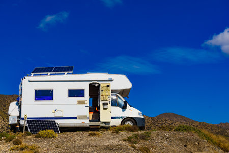 Camper rv with tilt solar photovoltaic panel on roof wild camping on nature. Power generation in holidays caravan trip.の写真素材