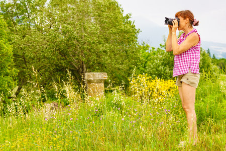 Tourist mature woman take travel picture from hill landscape, green nature in France.の写真素材