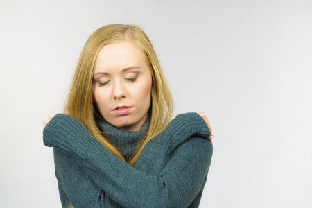 Sad worried young female. Huddled girl feels unhappy, problem in personal life, heartbreak. Mental illness.の写真素材