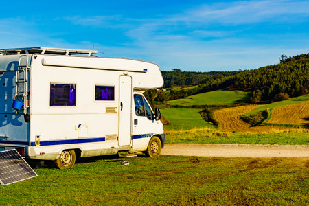 Charging battery at camper car. Caravan with portable solar photovoltaic panel camping on Verdicio beach, Asturias coast, northern Spain.の写真素材