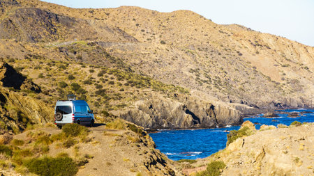 Campervan rv camping on rocky sea shore in Spain. Van life, motor home holidays.の写真素材