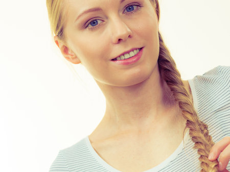 Portrait of smiling blonde girl with braid hair. Haircare, hairstyling.の写真素材