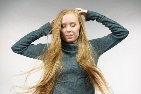 Young female with long hair flying around her face. Haircare concept.の写真素材