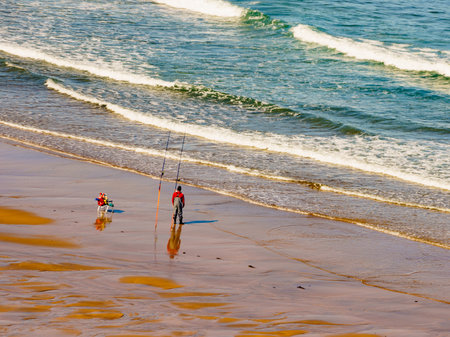 Fisherman angler with fishing rod on sea shore.の写真素材
