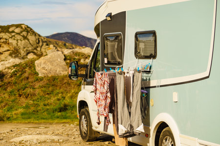 Washing laundry, clean clothes hanging to dry on clothesline outdoors at caravan. Camping on nature, lifestyle.の写真素材