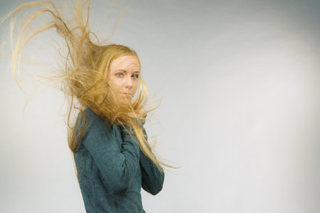 Sad melancholy young woman with blowing long blonde hair.の写真素材