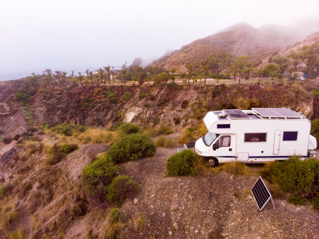 aerial view. Caravan with solar photovoltaic panels on roof camping on cliff sea shore. Mediterranean region of Villaricos, Almeria, eastern Andalusia, Spain.の写真素材