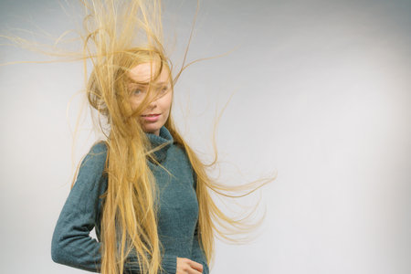 Young female with long hair flying around her face. Haircare concept.の写真素材