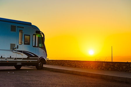 Caravan recreational vehicle at sunrise on mediterranean coast in Spain. Camping on nature. Vacation and traveling in motor home.の写真素材