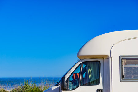 Camper rv caravan on mediterranean coast in Spain. Wild camping on nature beach. Holidays and traveling in motor home.の写真素材