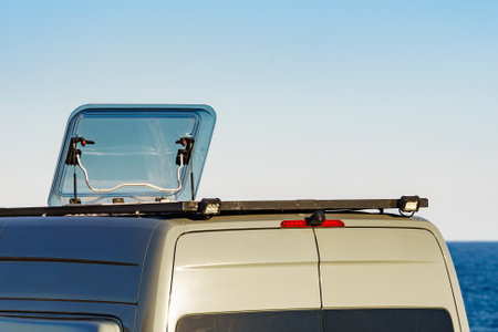 Sunroof, raisable panel window on roof top of rv camper van against blue sky. Traveling by motor home.の写真素材