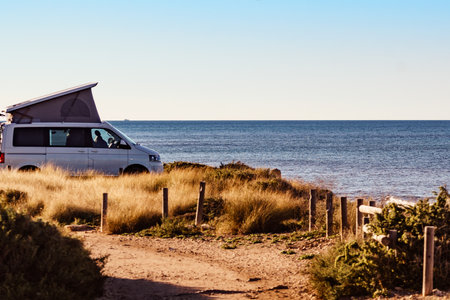 Camper van with roof top tent camping on mediterranean sea coast. Holidays and travel in motorhome.の写真素材