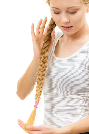 Blonde girl with long braid hair. Haircare, popular hairstyle.の写真素材