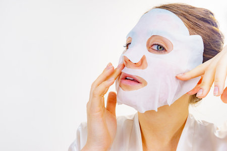 Woman with sheet mask on her face. Girl taking care of skin. Beauty treatment. Skincare.の写真素材