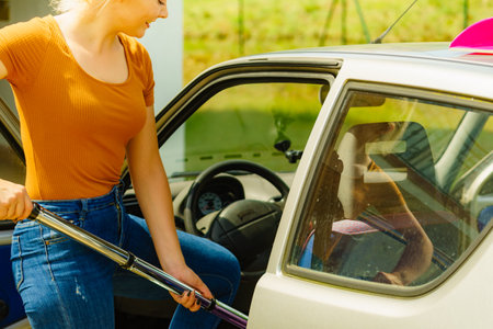 Woman hoovering car. Auto interior cleaning with vacuum cleaner.の写真素材