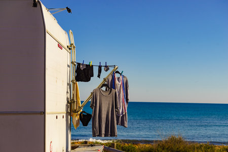 Wild camping on the seashore. Caravan vehicle with clothes hanging to dry. Holidays with motor home.の写真素材