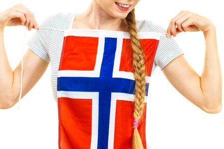 Blonde female student holding Norwegian flag on her chest. Travel and education. Learning foreign languages.の写真素材