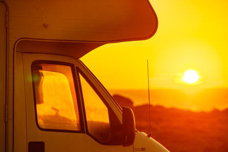 Camper vehicle camping on beach sea shore at sunrise. Adventure, travel with motor home.の写真素材