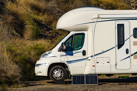 Small portable solar photovoltaic panel, charging battery at camper vehicle. Power generation in vacation caravan trip.の写真素材