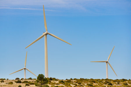 Wind turbine, power generator plant against blue sky. Generating green ecological energy. Windmill on eco field in France.の写真素材