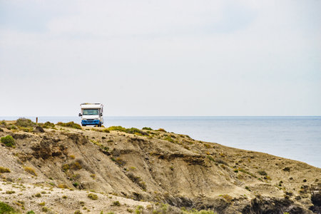 Camper car camping on cliff, spanish landscape along Almeria coast. Traveling with motor home.の写真素材