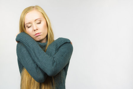 Sad worried young female. Huddled girl feels unhappy, problem in personal life, heartbreak. Mental illness.の写真素材