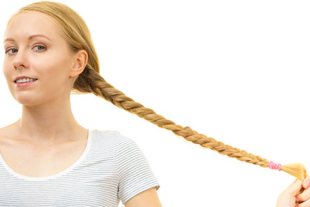 Blonde girl with long braid hair. Haircare, popular hairstyle.の写真素材