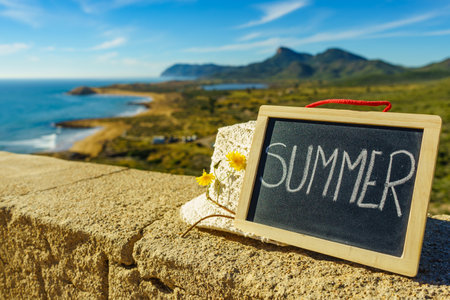 Black board with word summer against spanish sea coast. Landscape of Calblanque Park in Murcia Spain. Travel and holidays.の写真素材