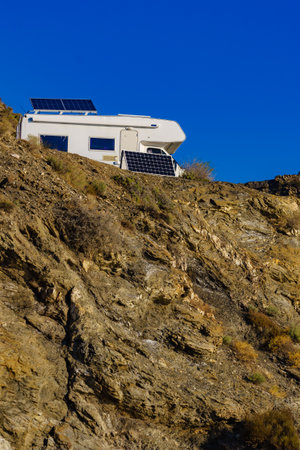 Camper rv with tilt solar photovoltaic panels on roof camping on nature in wintertime.の写真素材