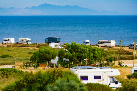 Many camper vehicles camping on seashore in Spain. Holidays, travel with motor home in wintertime.の写真素材