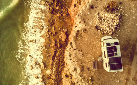 Caravan with solar panels on roof camping on coastal cliff. Mediterranean sea in Spain.の写真素材