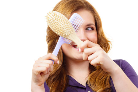Haircut coiffure haircare concept. Woman with long brown wavy hair holding brush and comb.の写真素材